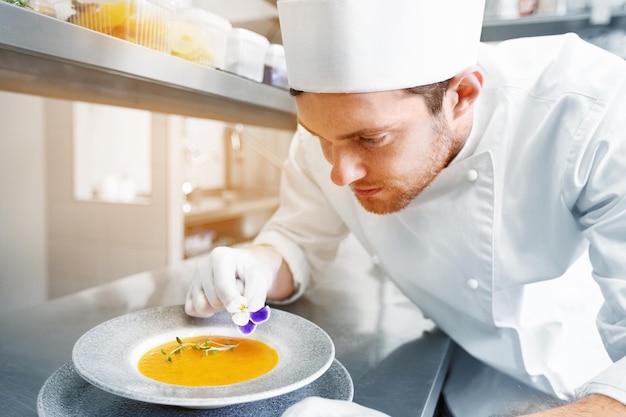 Chef testing a dish in a small kitchen